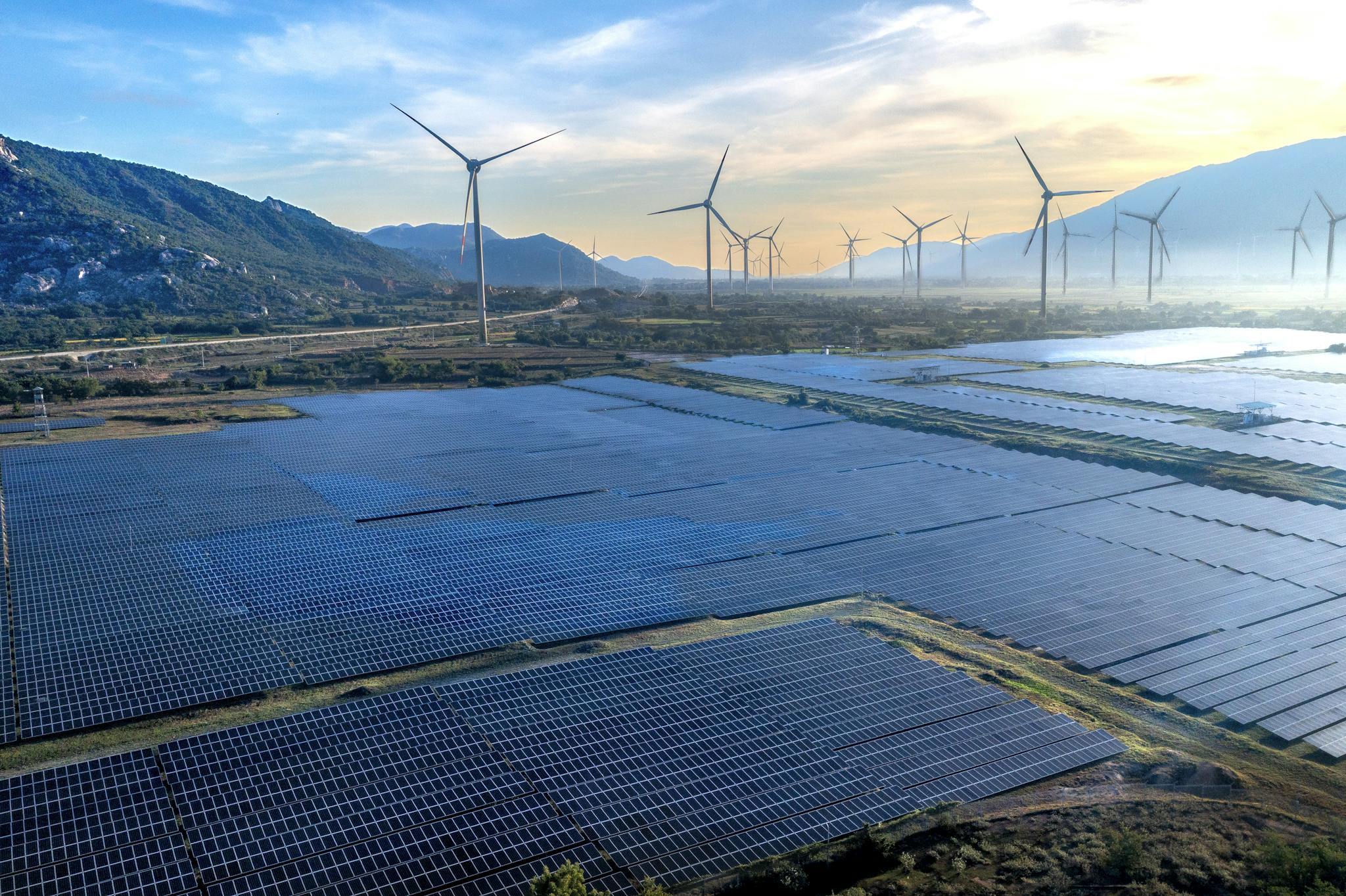 Expansive solar panel and wind turbine farm in Vietnam, showcasing renewable energy innovations.